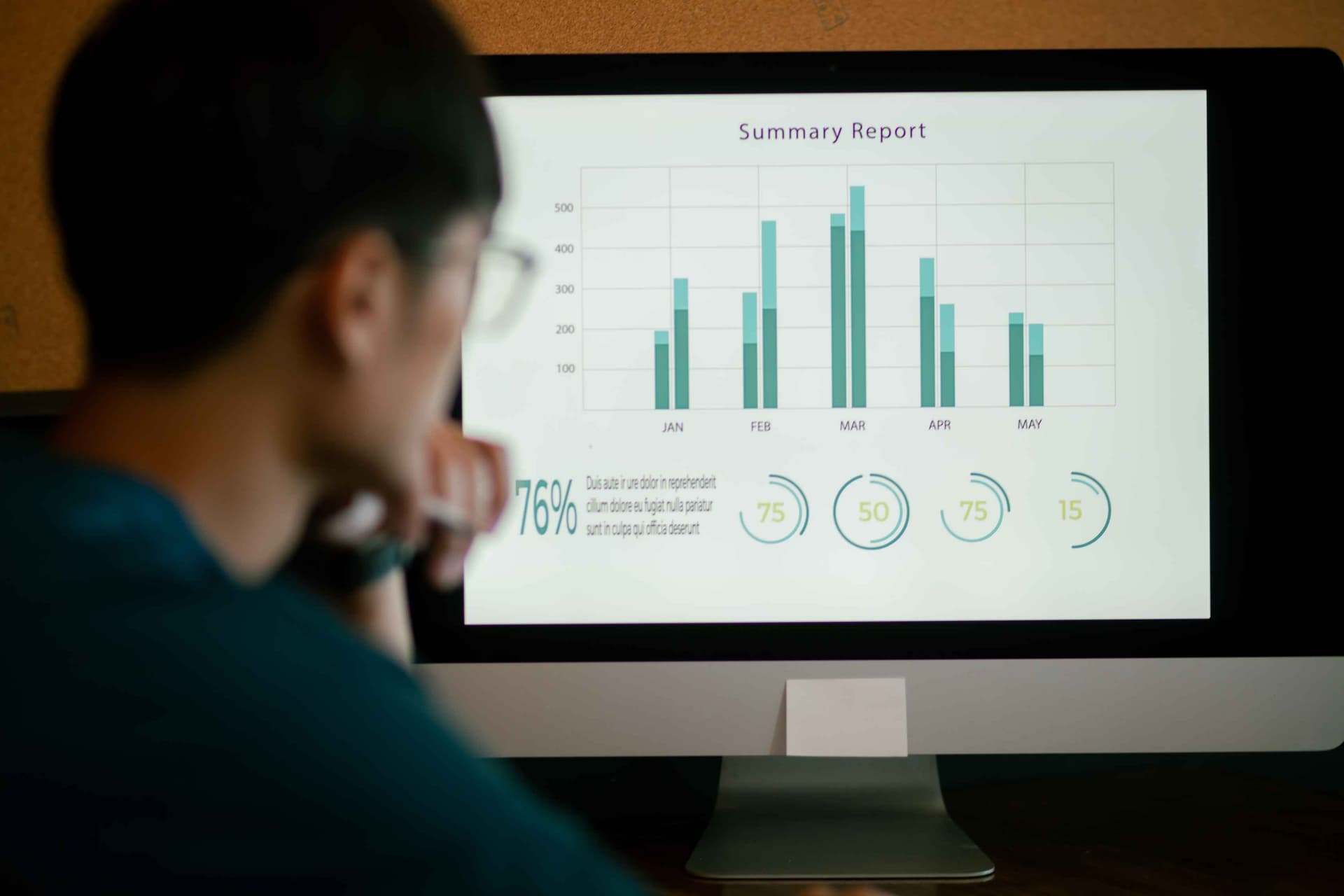 Professional thoughtfully reviewing monthly summary report and performance metrics on screen, reflecting untapped Dynamics 365 F&SCM data potential | Dynamics Monk